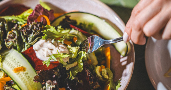Salada da PLATTER com folhas, pepino e legumes, servida em louça rosada